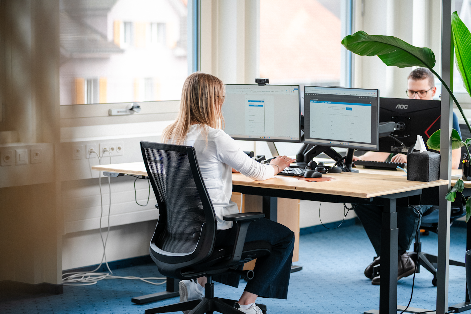 Mitarbeitende der Brogli Informatik GmbH bei der IT-Arbeit am Doppelbildschirm-Arbeitsplatz